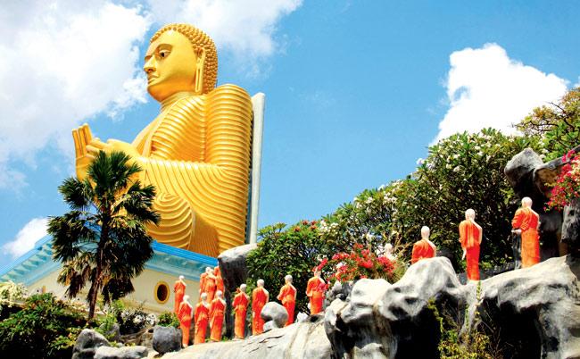 The Golden Temple at Dambulla has a gargantuan golden Buddha on the outside, flanked by monks draped in orange