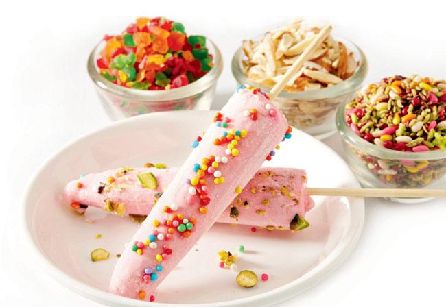 Strawberry Kulfi glazed in mango sauce and sprinkled with pieces of strawberry and crushed nuts