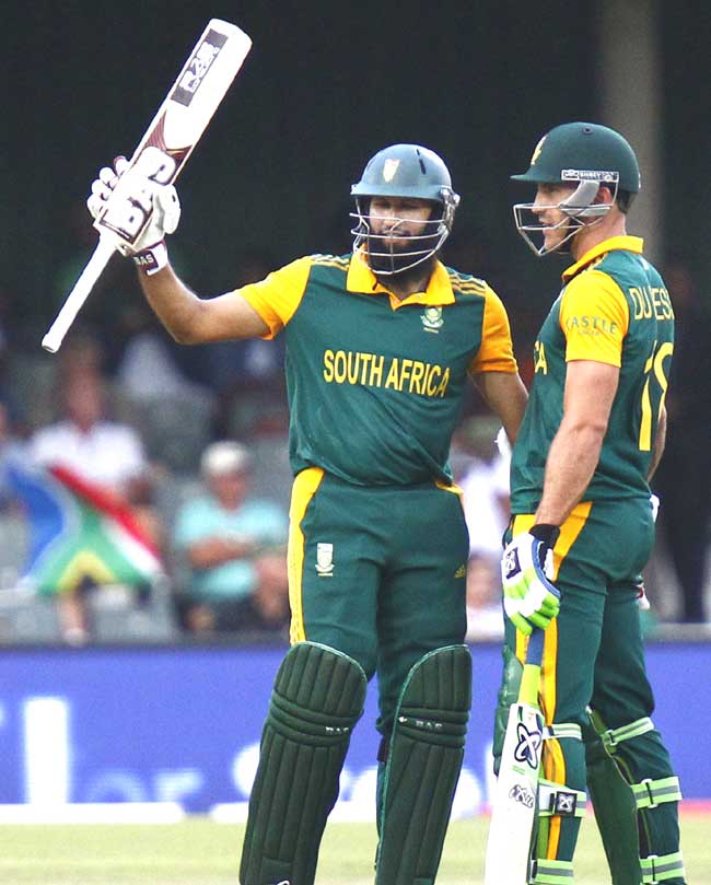 South African batsman Hashim Amla (L) raises his bat as he celebrates scroing half century (50 runs) during the third One Day International at East London cricket ground in East London. Pic/AFP
