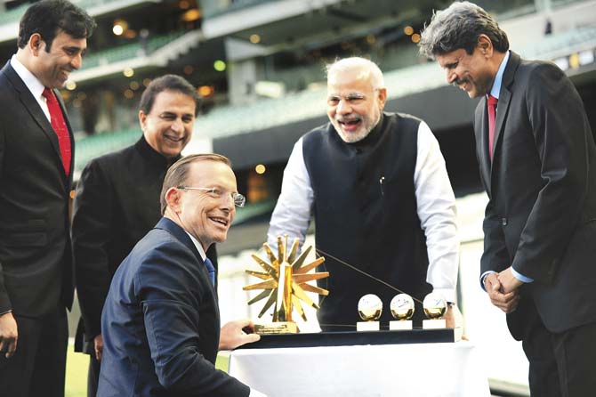 During his visit to Australia in November 2014, Narendra Modi presented a memento to Australian Prime Minister Tony Abbott at the Melbourne Cricket Ground a replica of Mahatma Gandhi’s charkha with three cricket balls signed by Modi and World Cup-winning Indian captains Kapil Dev and M S Dhoni. Pic/Getty Images
