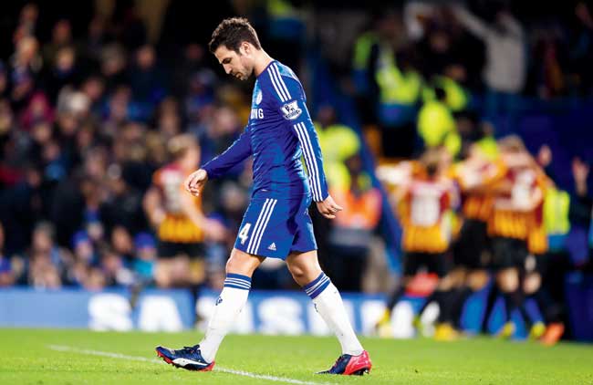 No Fab show this: A dejected Cesc Fabregas of Chelsea walks away after his team conceded their fourth goal while Bradford City players celebrate in the background during their FA Cup fourth round match at Stamford Bridge in London on Saturday. Pic/Getty Images