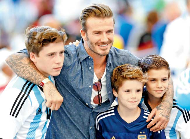 David Beckham with sons (left to right) Brooklyn, Cruz and Romeo during the FIFA World Cup in in Rio de Janeiro, Brazil last year. Pic/AFP