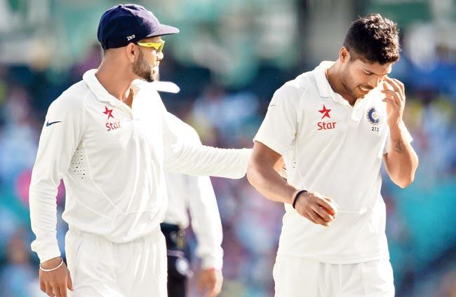 Captain Virat Kohli (left) encourages Umesh Yadav on Day 1 of the Sydney Test at SCG yesterday. Pic/AFP