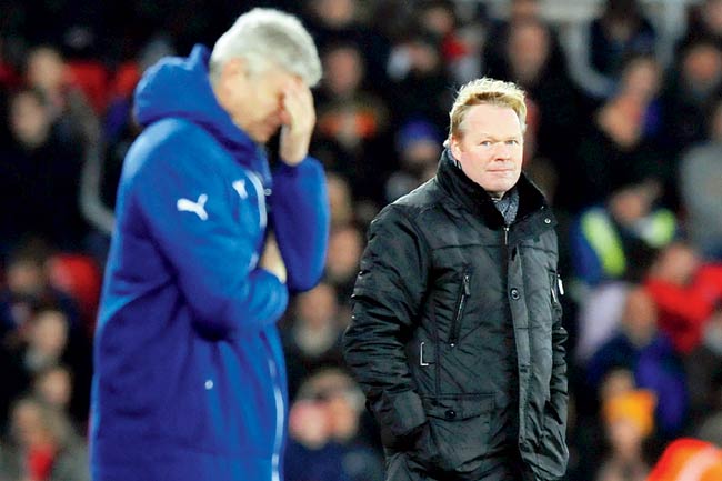 A disappointed Arsenal boss Arsene Wenger covers his face while Southampton manager Ronald Koeman (right) looks on