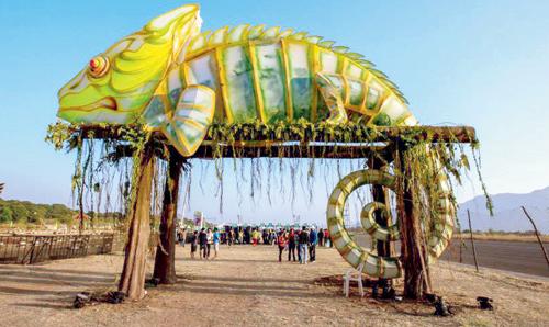 A giant-sized chameleon lords over the venue of the Enchanted Valley Carnival