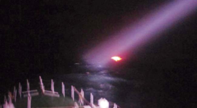 A Coast Guard Ship moving closer to the suspected boat in the high Sea. Pics/PTI and IANS