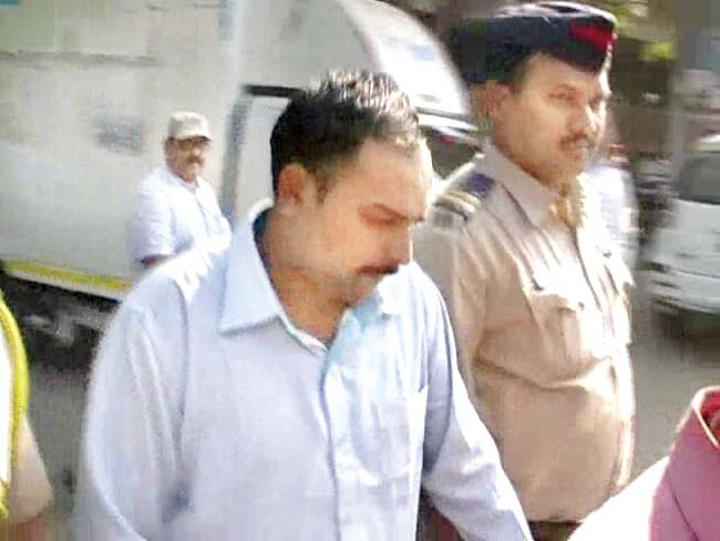 Thane police lead the guilty constable, Dinesh Sodnawar, to the police station