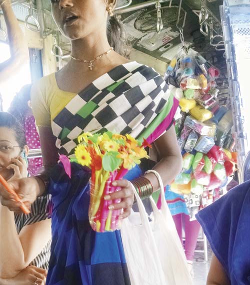 A vendor in a local train selling the flower-shaped pens