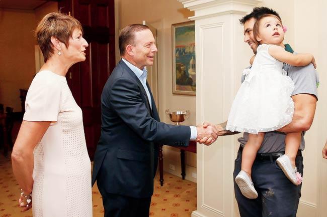 Mitchell Johnson and his daughter are greeted by the Australian Prime Minister