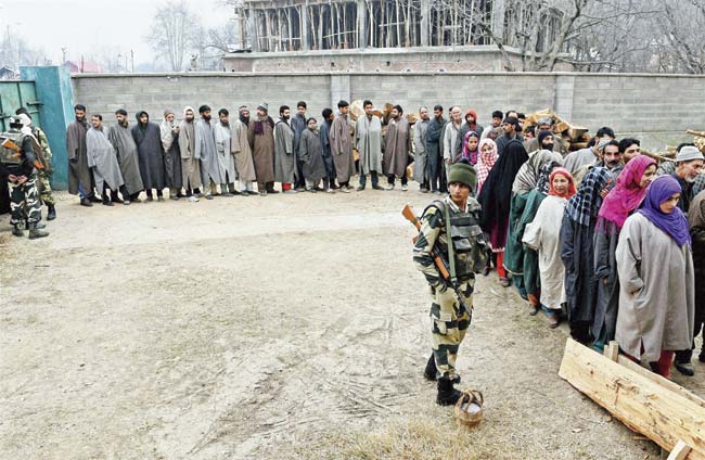Voters wait in queue at a polling station during the fourth phase of the J&K Assembly election in the Anantnag district on December 14, 2014. Politics in J&K has gone into a state of deep-freeze this winter, despite a fabulous election and robust campaigning by all four major political parties: PDP, BJP, NC and Congress. File pic