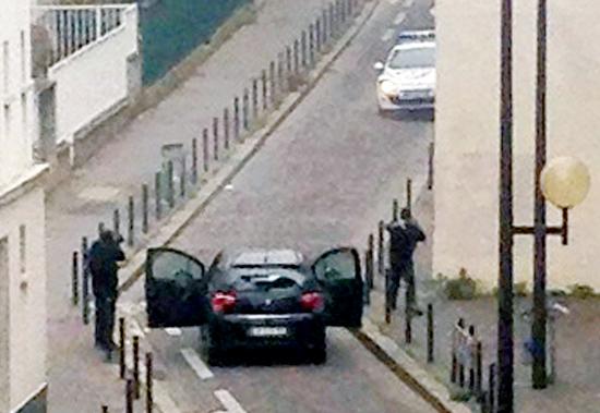 The armed gunmen face police officers near Charlie Hebdo office