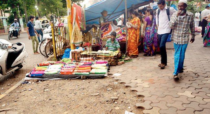 Full of holes: Corporators say even footpaths, like this one near Saat Rasta junction, are in a pitiable state and nothing is being done to repair them. PIC/Pradeep Dhivar