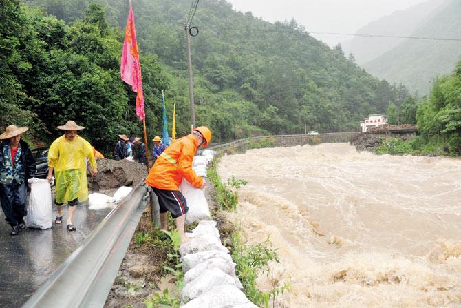 Rescue workers strengthen a dyke during a storm caused by typhoon Chan-hom in east China