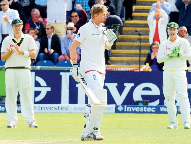 England’s Joe Root kisses the badge on his helmet as he celebrates his century during Day One of the first Ashes Test in Cardiff on Wednesday.  Australia’s wicketkeeper Brad Haddin right and Shane Watson applaud. PIC/PTI