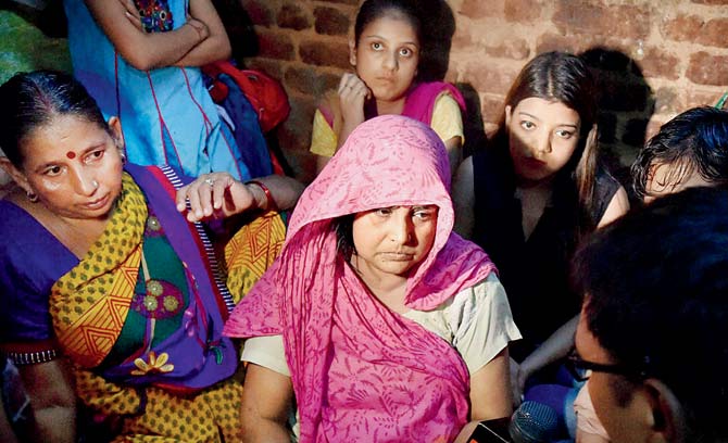 The victim’s mother and family in Anand Parbat, New Delhi. Pic/PTI