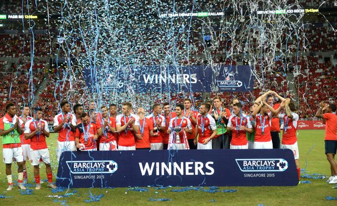 Arsenal team celebrates winning the Barclays Asia Trophy 2015 after beating Everton 3-1 at Singapore National Stadium in Singapore. Pic/AFP