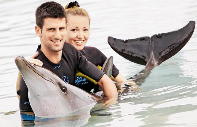 Serbian tennis player Novak Djokovic and wife (then girlfriend) Jelena Ristic play with a dolphin at the Atlantis Hotel, Dubai, while there for the 2011 Dubai Tennis Championships. Pic/AFP
