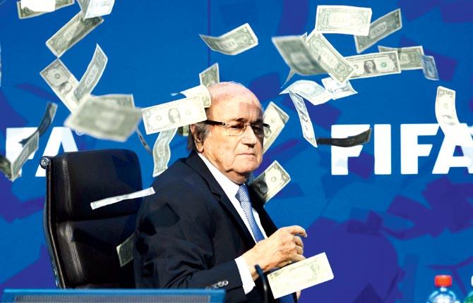 An embarrassed Blatter looks on with fake dollar notes flying around him, thrown by Brodkin in Zurich yesterday. Pics/AFP