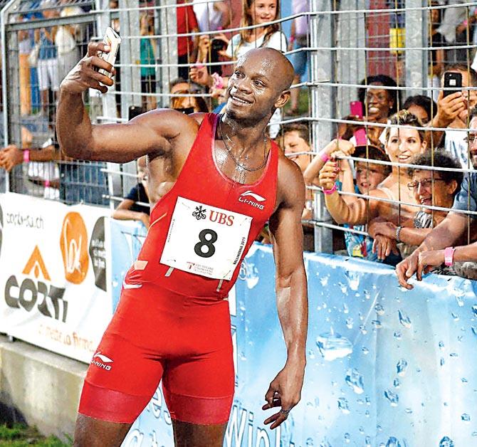 Asafa Powell takes a selfie with fans after winning the men