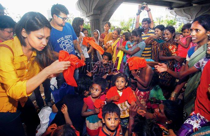 TIME FOR GIVING: The Happy Birthday Bharat Twitter and Facebook members distribute T-shirts to the slum children below the flyover near Oberoi Mall in Goregaon. PICS/SAMEER MARKANDE