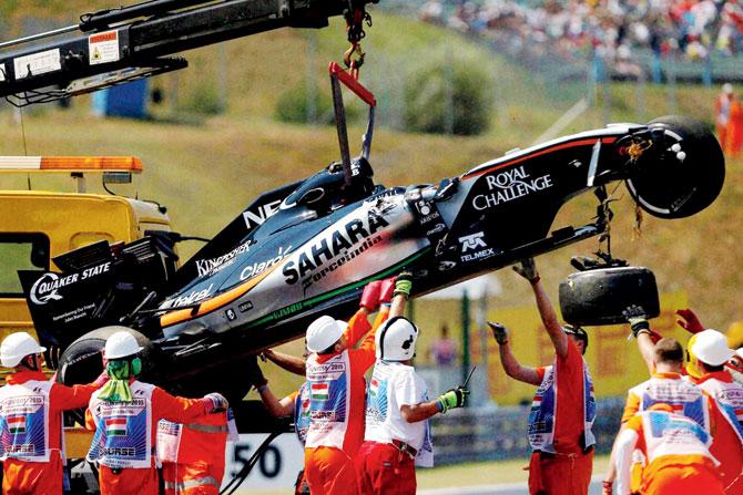 Sergio Perez’s Force India is removed by a crane after his crash in Budapest yesterday. PIC: AP/PTI