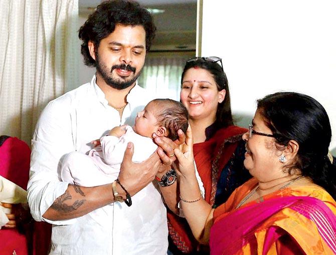 Cricketer S Sreesanth holds his daughter as his wife Bhuvaneshwari Kumari and mother look on at his Kochi residence yesterday. Pic/PTI