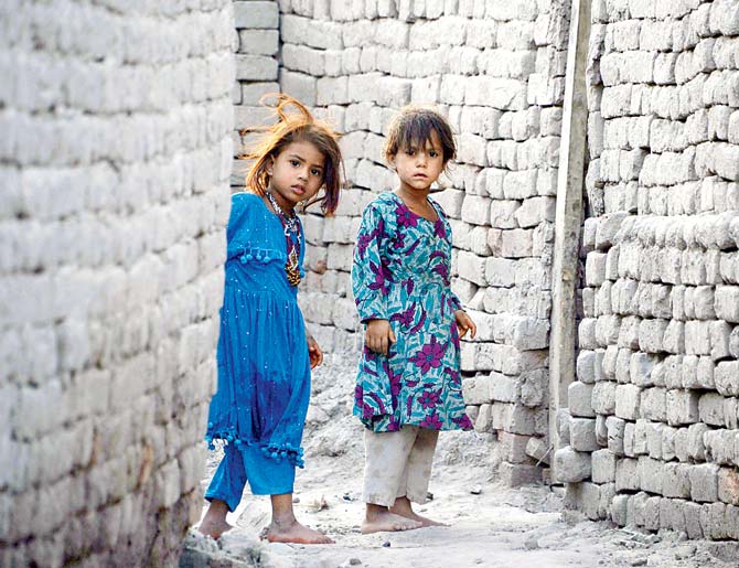 LOST INNOCENCE: Afghan girls who fled from Kot district of the eastern Nangarhar province, following threats from the IS to leave their homes, look around a corner next to their temporary homes in Jalalabad. IS fighters ordered families whose members were working for the government or Afghan National Security Forces to leave their homes