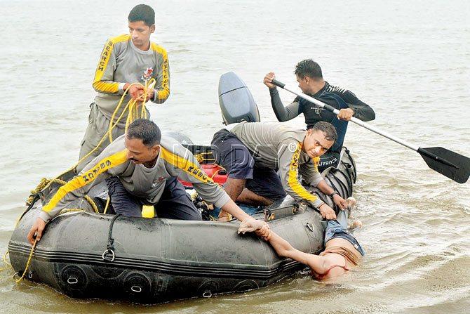 Young life snuffed out: The team comes back to the beach with the 16-year-old’s body as his bereaved relatives (right) look on.  PICS/NIMESH DAVE