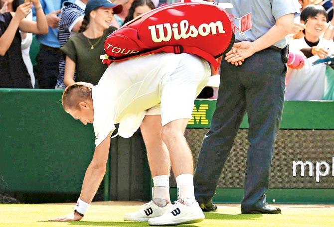Jarkko Nieminen touches the Centre Court grass on his last Wimbledon appearance against  Novak Djokovic yesterday. Pic/Getty Images