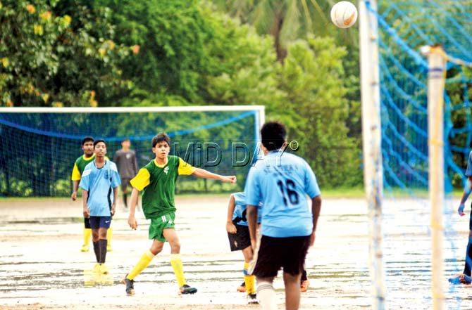 Up in the air: Rohan Travas of Holy Family (in green) watches his shot sail into goal during a MSSA U-16 Div II inter-school football match against St Xavier