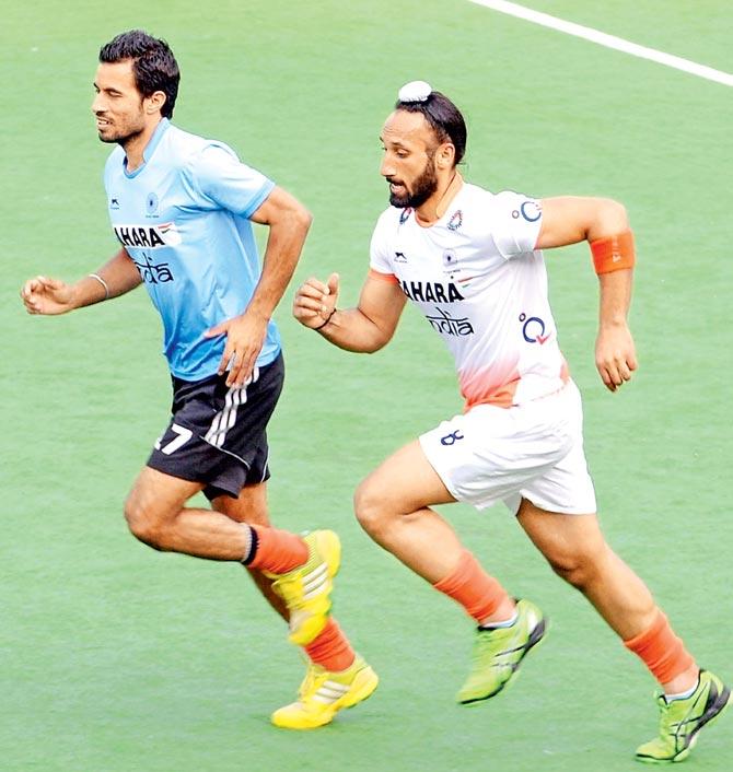 India captain Sardar Singh warms up with his teammate Gurbaj Singh (left) during a training session. Pic/AFP
