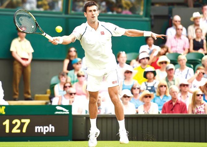 Novak Djokovic returns to Bernard Tomic at Wimbledon yesterday. Pic/Getty Images