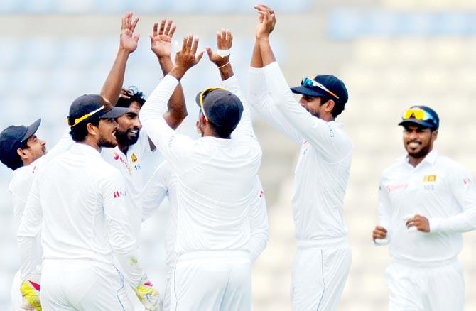 Nuwan Pradeep (centre) celebrates a wicket with teammates on Saturday. Pic/AFP