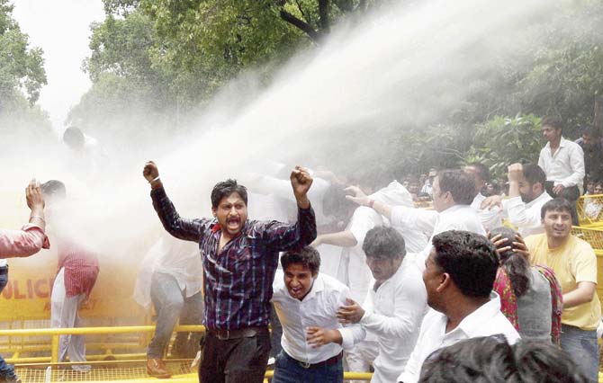 Police use water cannons to disperse a Youth Congress protest over the Vyapam scam, near the BJP office in New Delhi on Wednesday. Scores have died mysterious deaths in MP, UP, and Rajasthan in connection with the case, but this has only now begun to be highlighted. Pic/PTI