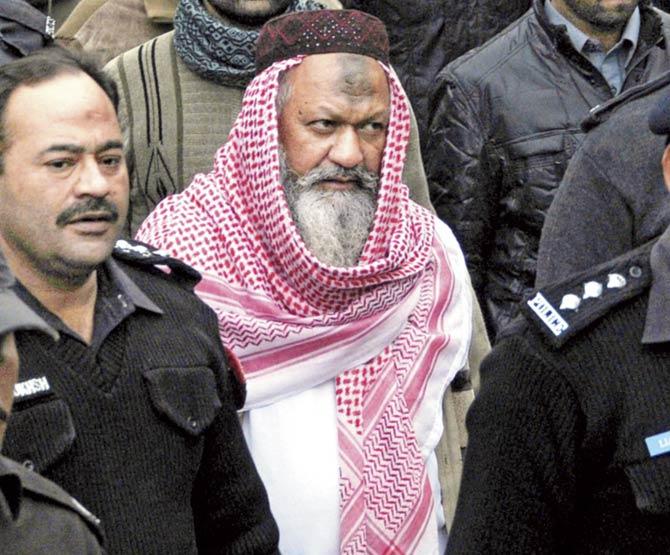 A file photo from December 2014 shows Pakistan Police escorting the leader of banned sectarian outfit Lashkar-e-Jhangvi (LeJ), Malik Ishaq (in white) to the high court in Lahore. Pic/AFP