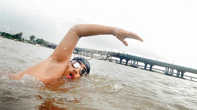 Manav Mehta coached by Santosh Manohar Patil, at the Uran Creek on Thursday. The Kharghar resident was the youngest member of the  Indian Open Water  Swim Team that swam from Goa to Mumbai this year, setting a World Record for the longest open water relay swim. PIC/SAMEER MARKANDE