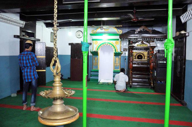The sanctum sanctorum with a traditional Kerala-style lamp, and a mimber, or the pulpit, from where the Imam delivers sermons, that has intricate carvings and lacquer work, unique to southern India