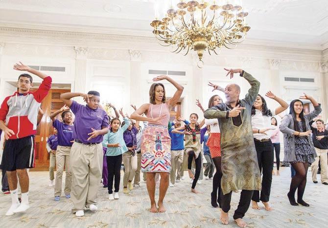 Michelle Obama (centre) tries out traditional Bollywood- style dance moves, led by choreographer, Nakul Dev Mahajan