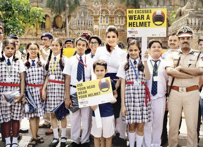 Actor Raveena Tandon with school kids in an awareness campaign for using helmets, at CST in Mumbai; Traffic police constables and college students take a selfie wearing safety helmets distributed by traffic police on the occasion of Yuva Suraksha Abhiyaan Week in Thane. Pics/PTI