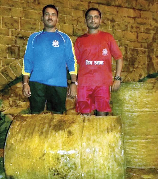 Lifeguards Ravi Wadhave (in blue) and Kiran Ganjve with the barrels found at Picnic Cottage beach at Versova