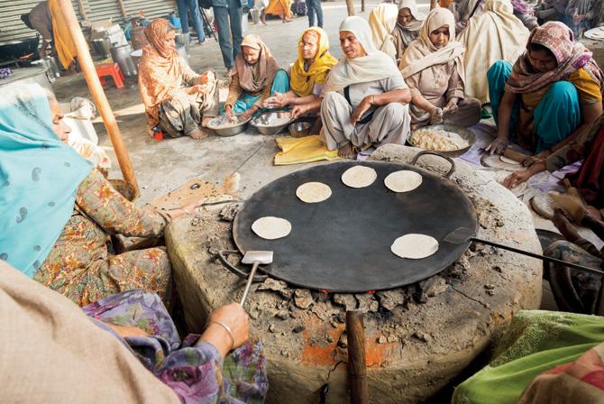 Women in community kitchens offering their service by making meals for mela attendees. (Volume 4: Seva, Sadhana, Satsang)