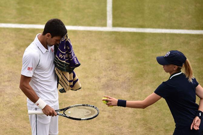 Novak Djokovic with a ball girl during a match