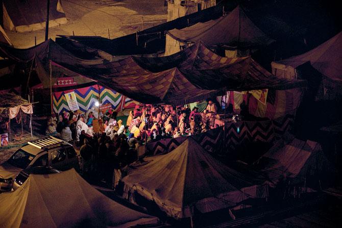 On a cold night, eager disciples hearing a sermon from their Guru as the Kumbh landscape transforms into a mega university for its duration (Volume 5: Guru, Disciple, University)