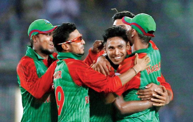 Mustafizur Rahman being congratulated by teammates. Pic/AP/PTI