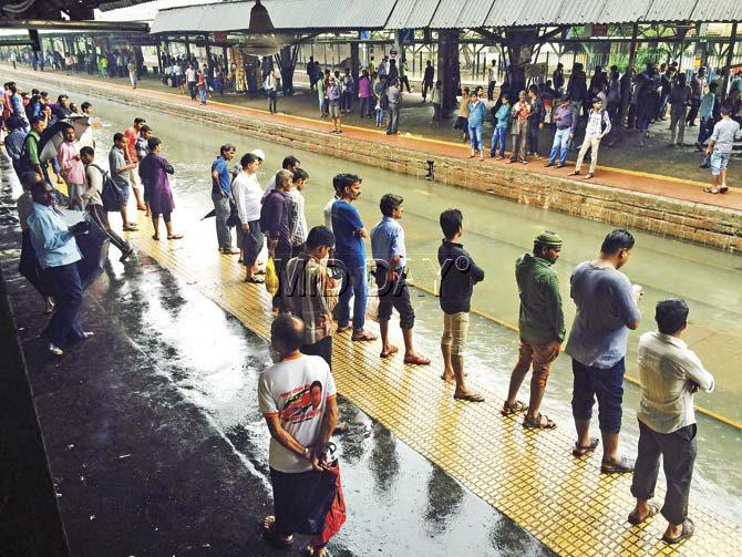 Commuters waiting for a train at Sion station yesterday. Almost all the servcies on the Central line were cancelled immediately after the downpour. Pic/Atul kamble