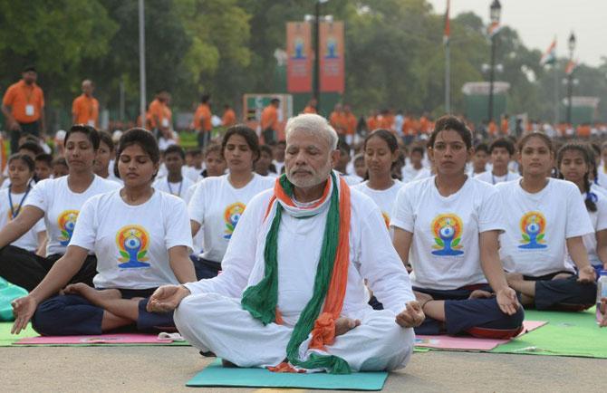 Indian Prime Minister Narendra Modi (C) participates in a mass yoga session along with other Indian yoga practitioners to mark the International Yoga Day on Rajpath in New Delhi. AFP PHOTO / PRAKASH SINGH