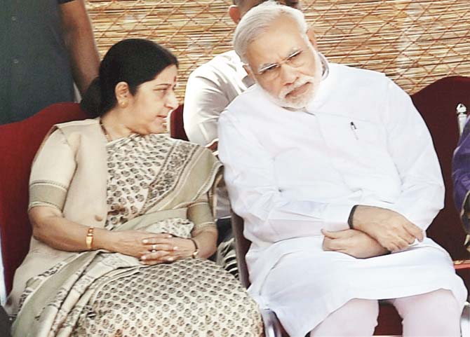 Prime Minister Narendra Modi and External Affairs Minister Sushma Swaraj at the Rashtrapati Bhavan, New Delhi on Friday. Both she and the Rajasthan Chief Minister Vasundhara Raje now owe survival in office to the PM, and not merely the support they draw from colleagues and party, or their work. Pic/PTI