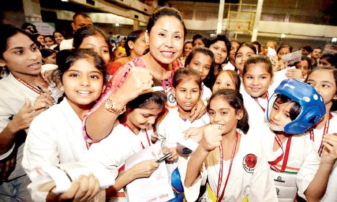 Sarita Devi poses with young kids during the inauguration of a self defence championship in Kolkata on Saturday. Pic/PTI