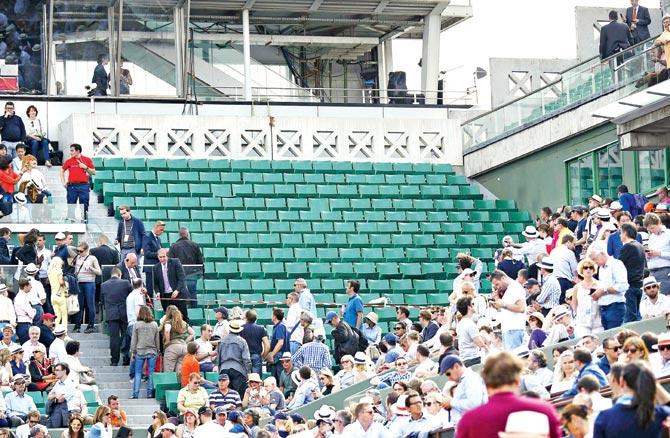 Security guards cordon off  a section of the stands after a large piece of  metal paneling fell after being blown off during quarter-final between Kei Nishikori and Jo-Wilfried Tsonga yesterday. The mishap caused play to be held up and left at least one fan injured. Pic/AFP 