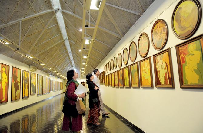 Indian visitors view the paintings of artist Jatin Das on display at the Amdavad Ni Gufa Gallery in Ahmedabad on April 13, 2011. Das is one of India’s most prolific figurative painters. PIC/AFP